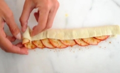 Elle met une couche de pâte sur les pommes: le résultat final est superbe et... délicieux!