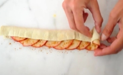 Elle met une couche de pâte sur les pommes : le résultat final est superbe et... délicieux !