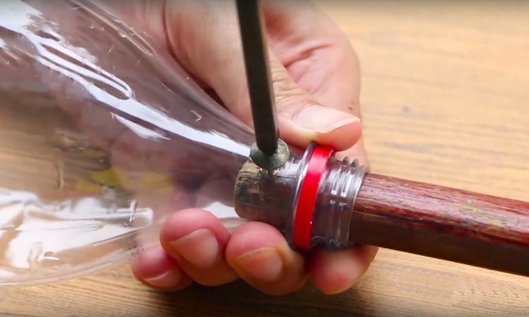 En vissant un manche à balai dans une bouteille de plastique, il se facilite la vie !!